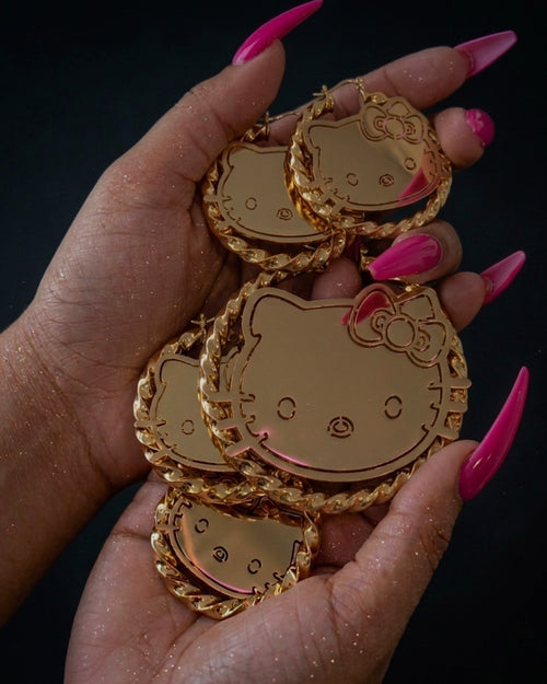 Oversized cartoon face gold hoop earrings stainless steel statement jewelry held in hand